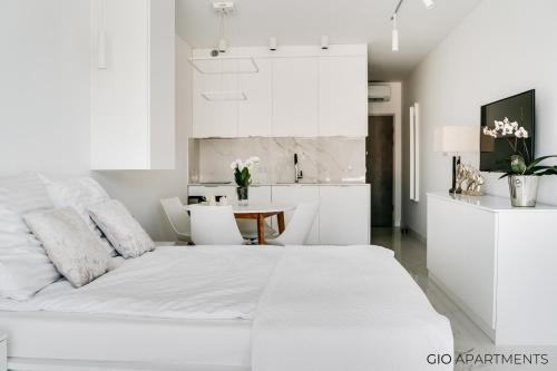 a white bedroom with a large bed and a table at GIO Apartments, Luxury, Old Town Cracow in Krakow