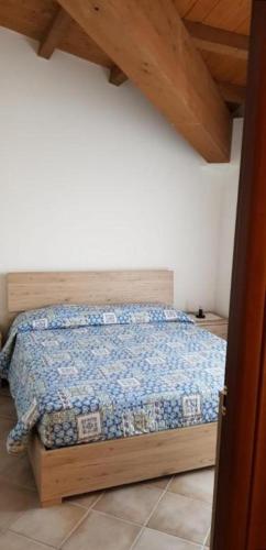 a bedroom with a bed with a wooden head board at La casa del Re in Sipicciano