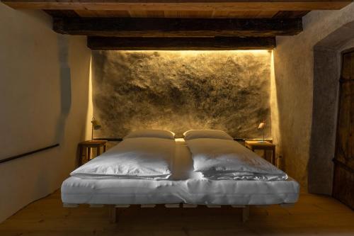 ein Bett mit zwei Kissen auf einem Zimmer in der Unterkunft Bauernhof Hof Unternberg in Margreid an der Weinstraße