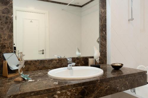 a bathroom with a sink and a mirror at Infinity pool & Amazing Sunset Ocean View in Funchal