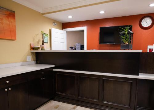 a kitchen with a large counter with a tv on the wall at Scandia Motel in Carlsbad