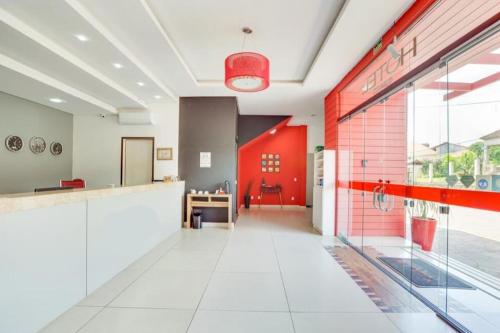 an empty lobby with a red door in a building at Hotel Comoditá Ltda in Sapiranga