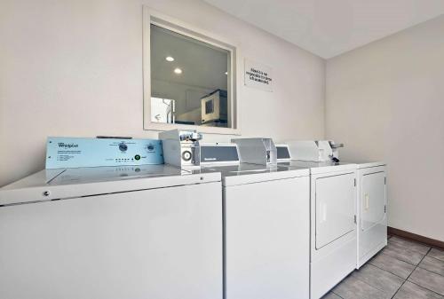 a laundry room with white cabinets and a mirror at Motel 6-Alamogordo, NM in Alamogordo