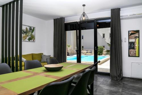 a dining room with a green table and chairs at Villa Kajgo-Pag in Pag