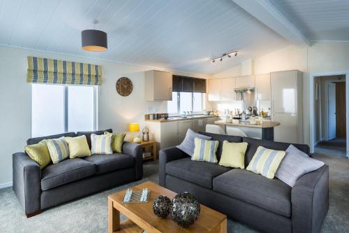 sala de estar con 2 sofás y cocina en King's Lynn Caravan & Camping Park en Kings Lynn
