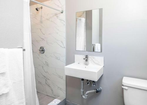 a bathroom with a white sink and a mirror at Motel 6 San Pedro, CA Port of Los Angeles in San Pedro