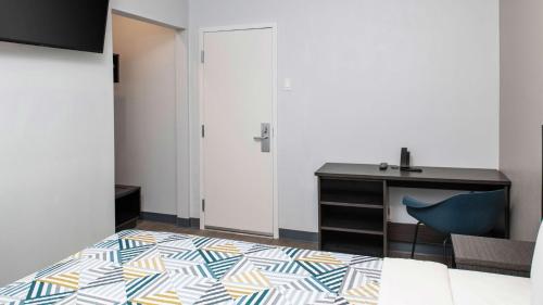a bedroom with a desk and a blue chair at Motel 6 San Pedro, CA Port of Los Angeles in San Pedro