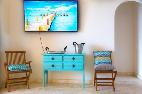 a room with a blue dresser and a painting of a pier at Joe‘s Condo at Isla 33 in Isla Mujeres