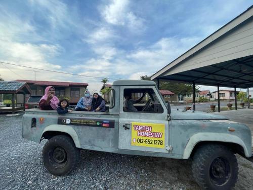 a group of people sitting in a pick up truck at Tamteh Homestay in Ayer Hitam