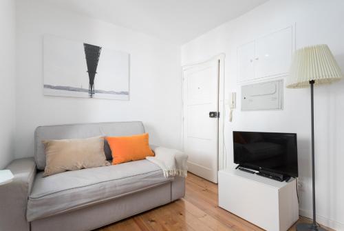 a living room with a couch and a television at Apartments Center Alfama in Lisbon