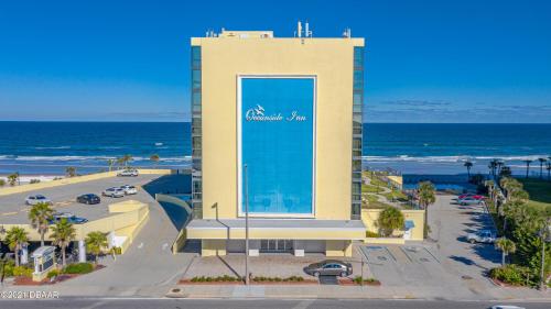 a building with a sign on it next to the ocean at Oceanside Inn Hotel in Daytona Beach Shores