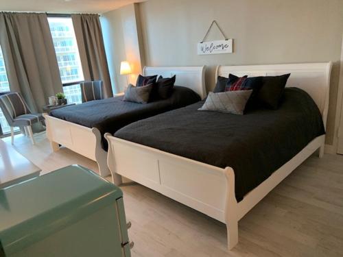 a bedroom with two beds and a living room at Oceanside Inn Hotel in Daytona Beach Shores