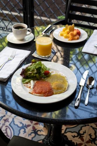 a table with two plates of food and a cup of coffee at Künük Hotel Boutique in Mérida