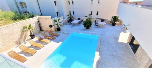 an overhead view of a swimming pool with lounge chairs at Villa Kajgo-Pag in Pag