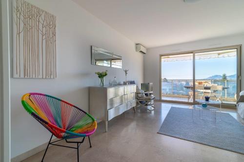 sala de estar con silla colorida y escritorio en Apartment In A Residence With Swimming Pool Wifi en Cannes