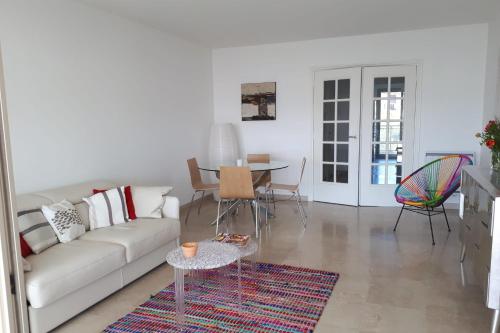 sala de estar con sofá, mesa y sillas en Apartment In A Residence With Swimming Pool Wifi en Cannes
