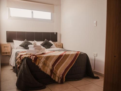 1 dormitorio con 1 cama grande y toallas. en VIÑAS ALTAS en Maipú