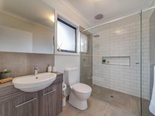 a bathroom with a toilet and a sink and a shower at Merchant's Court, Quiet and Central 3 bedroom townhouse in Wangaratta
