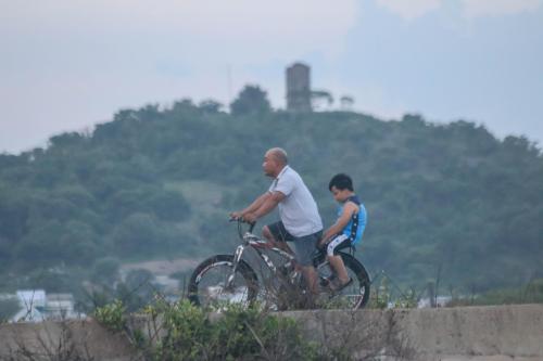a man and a boy riding a bike at Cô Tư's Homestay in Phan Thiet