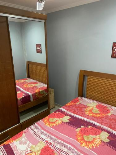 a bedroom with two beds and a large mirror at Casa com 2 quartos na Prainha em Arraial do Cabo, 20 METROS DA PRAIA in Arraial do Cabo