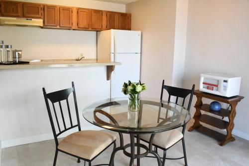 a kitchen with a glass table with chairs and a refrigerator at La Jolla Cove Suites in San Diego
