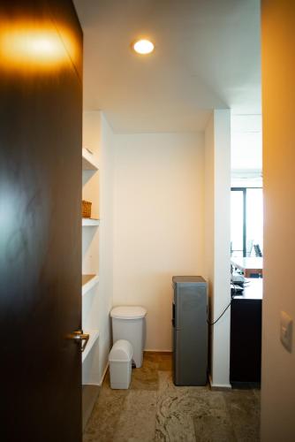 a small bathroom with a refrigerator and a toilet at HERMOSO DEPATAMENTO EN PLAYA PROGRESO in Chicxulub
