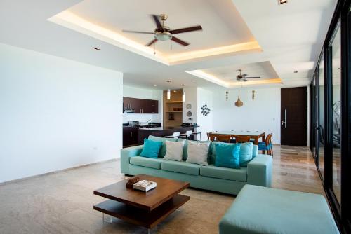 a living room with a blue couch and a table at HERMOSO DEPATAMENTO EN PLAYA PROGRESO in Chicxulub