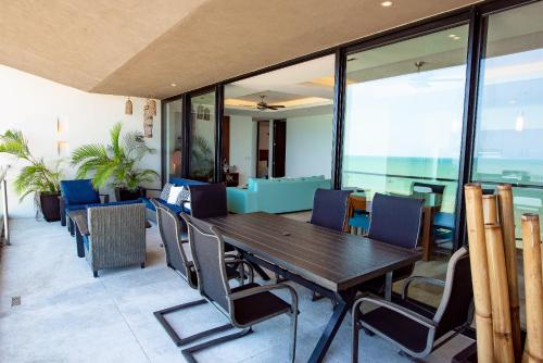 a dining room with a wooden table and chairs at HERMOSO DEPATAMENTO EN PLAYA PROGRESO in Chicxulub