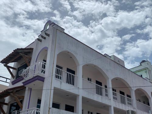 a white building with balconies on the side of it at Hotel Marcianito in Isla Mujeres