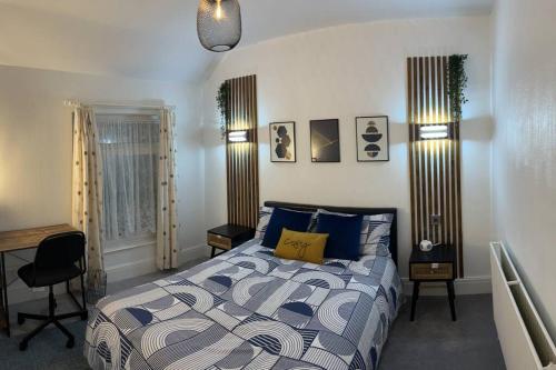 een slaapkamer met een bed met een blauw en wit dekbed bij Heritage holiday house in Pembrokeshire