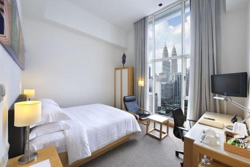um quarto de hotel com uma cama e uma grande janela em Hotel Capitol Kuala Lumpur em Kuala Lumpur
