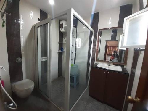 a bathroom with a shower and a toilet and a sink at Jubilee Hills Duplex Villa For Family Stay in Hyderabad