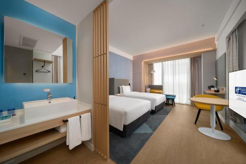 a hotel room with a bed and a sink and a tub at Holiday Inn Express Nanchang Riverside, an IHG Hotel in Nanchang