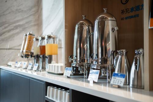 a counter with a row of silver kettles on it at Holiday Inn Express Nanchang Riverside by IHG in Nanchang