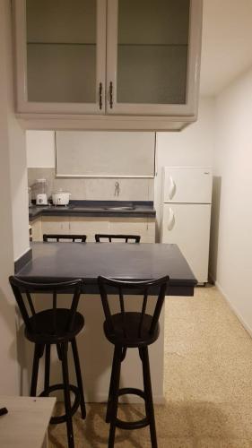 a kitchen with a table and two chairs and a refrigerator at Villa del Mar Departamento 1 I in Salinas