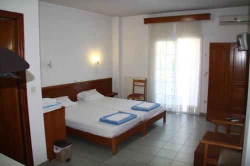 a bedroom with a bed and a television in it at Galanis Studios and Apartments in Platamonas