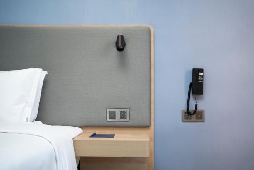 a bedroom with a bed and a phone on a wall at Holiday Inn Express Nanchang Riverside by IHG in Nanchang