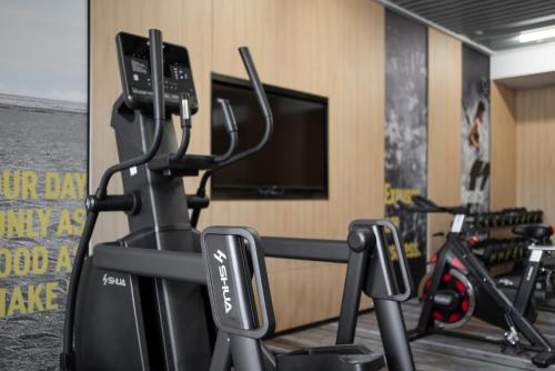 a gym with several exercise bikes and a flat screen tv at Holiday Inn Express Nanchang Riverside by IHG in Nanchang