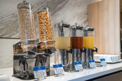 a counter with several glass containers filled with different types of food at Holiday Inn Express Nanchang Riverside by IHG in Nanchang