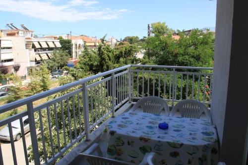 a table on a balcony with a view of a city at Galanis Studios and Apartments in Platamonas
