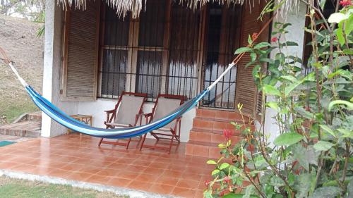 a hammock on the porch of a house at Hosteria Cumilinche in Same