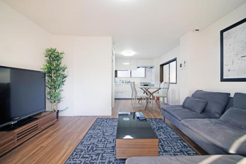 a living room with a couch and a flat screen tv at MUMU HOUSE in Tokyo
