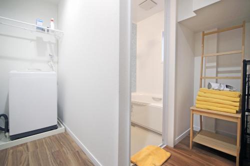 a small bathroom with a refrigerator and a mirror at MUMU HOUSE in Tokyo