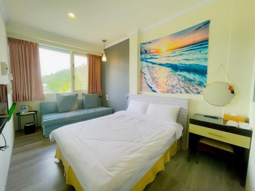 a bedroom with a bed and a painting on the wall at Xingyue 2 Guesthouse in Yuchi