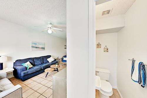 a living room and kitchen with a blue couch at Dolphin Condominiums #12 in South Padre Island