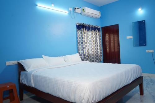 Dormitorio azul con cama grande y pared azul en SSK HOME STAY en Pondicherry