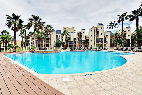 a large swimming pool with palm trees and buildings at Solare Garden Villa 877 in South Padre Island