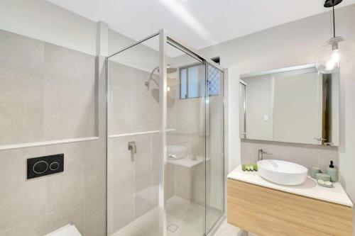 a bathroom with a glass shower and a sink at Esprit 29 in Palm Cove