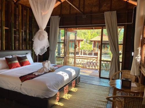 a bedroom with a bed in a room with a porch at Say Love Baan Sapan บอกฮักบ้านสะปัน in Ban Huai Ti