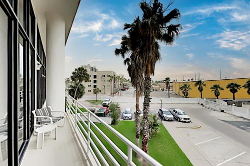a balcony with a palm tree and a parking lot at Sunchase IV II in South Padre Island